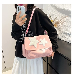 Pink canvas messenger bag with plush white star detail and adjustable strap