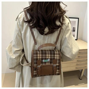 Detailed back view of model wearing a vintage plaid backpack with embroidery