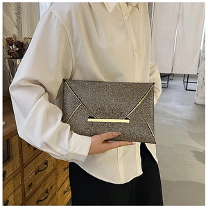 Gros plan d'une pochette de soirée champagne à paillettes scintillantes et garniture dorée