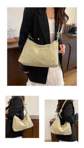 Detailed view of the pleated texture and knotted strap on the cream hobo shoulder bag