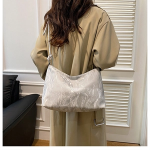 Detail of silver pleated hobo bag showing large capacity and textured metallic finish