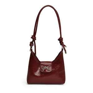 Chic burgundy shoulder bag with glossy patent leather finish and silver bow detail