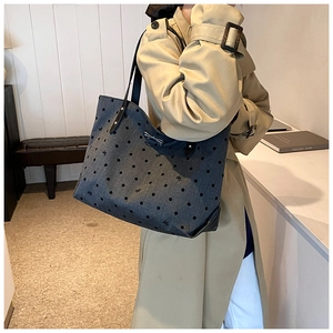 Detailed close-up of large tote bag featuring black polka dots and silver bow decoration