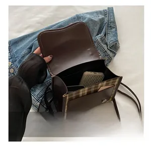 Vue intérieure d'un sac à bandoulière à carreaux montrant sa capacité et ses compartiments
