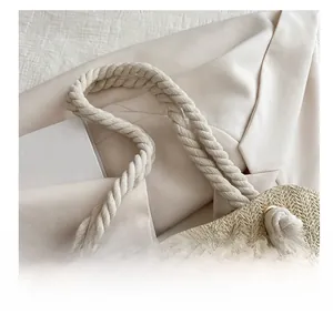 Détail du sac cabas en paille tressée avec poignées en corde de coton et œillets en métal