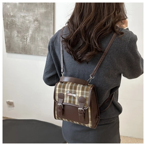 Détail d'un mini sac à dos à carreaux vintage avec broderie teckel et sangles à boucles