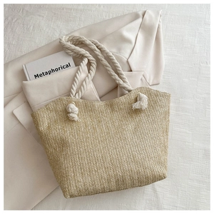 Détail de la texture du sac cabas en paille et de la poignée en corde épaisse d'été