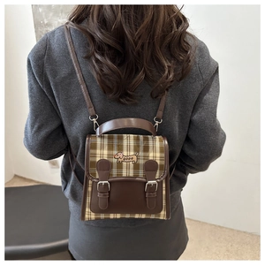 Détail d'un mini sac à dos vintage à carreaux avec broderie de teckel coloré