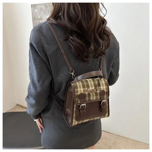 Détail du sac à dos vintage à carreaux avec broderie de teckel mignon sur le rabat