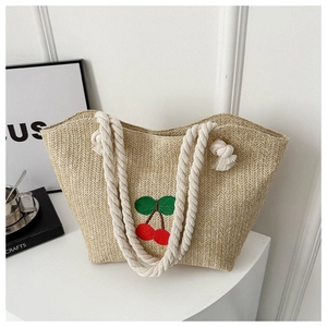 Détail du sac cabas en paille tissée avec broderie cerise et anses en corde de coton