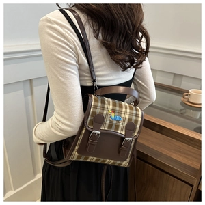 Détail d'un petit sac à dos à carreaux avec garniture en similicuir marron