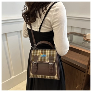 Détail du sac à carreaux avec broderie chien bleu porté à l'épaule par le mannequin