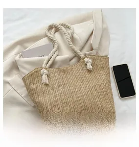 Detail of the woven straw tote bag texture with natural rope handles on white fabric