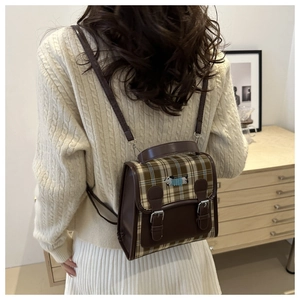 Detail of plaid student backpack featuring a dachshund embroidery and faux leather straps