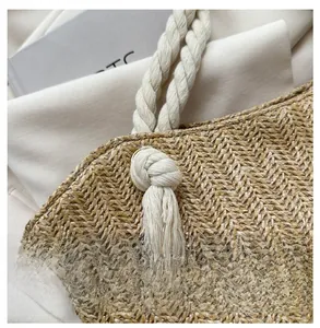 Detail of hand-woven straw tote featuring V-shaped texture and decorative tassels