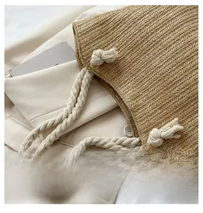 Close-up of woven straw tote bag with thick cotton rope shoulder strap and rustic texture