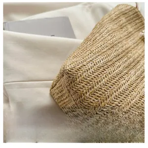 Detailed macro view of the dense herringbone weave pattern on a natural straw tote bag