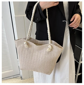Detailed side view of off-white woven straw tote bag with elegant white rope handle