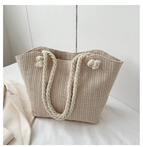 Close-up of beige straw tote bag with V-shaped weave pattern and cotton rope handle