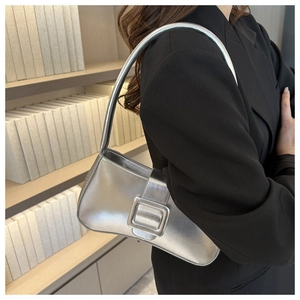 Detalle del bolso de hombro plateado metalizado con una gran hebilla cuadrada decorativa