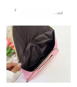 Détail de la pochette rose à motif d'étoiles avec bordure dorée et plusieurs compartiments