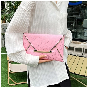 Détail d'une pochette enveloppe rose avec étoiles argentées et fermoir en métal doré