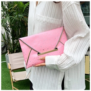 Détail de la pochette enveloppe rose avec motifs étoiles argentées et fermoir doré