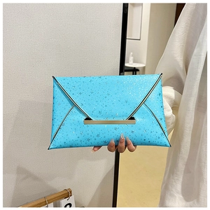 Détail d'une pochette enveloppe bleue étoilée avec fermoir doré pour femmes