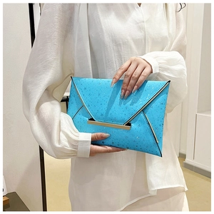 Détail de la pochette enveloppe bleu vif avec imprimés étoiles et fermoir en métal doré
