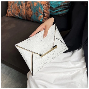 Détail d'une pochette enveloppe blanche pailletée avec étoiles et fermoir doré