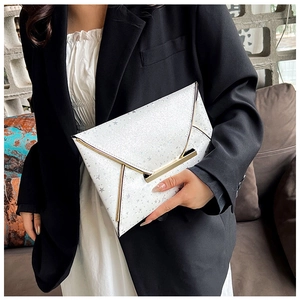 Détail de la pochette enveloppe blanche à motif étoiles avec bordure en métal doré chic