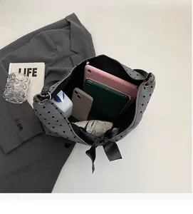 Spacious interior of gray polka dot tote bag holding tablets and essentials
