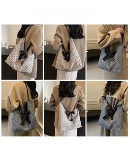 Polka dot shoulder tote bag shown on model highlighting its large size and capacity