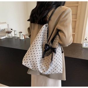 Detail of grey heart pattern tote bag with decorative black satin and silver bows