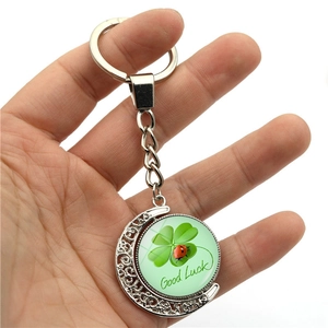 Silver moon keychain with rotating double-sided green four-leaf clover and ladybug charm