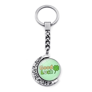 Close-up of rotatable silver metal keychain with double-sided green lucky clover charm