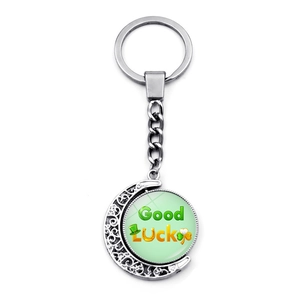 Macro detail of rotating St. Patrick's Day moon keychain with Good Luck glass charm