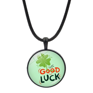 Detailed macro view of a green four-leaf clover pendant with Good Luck text on a black cord