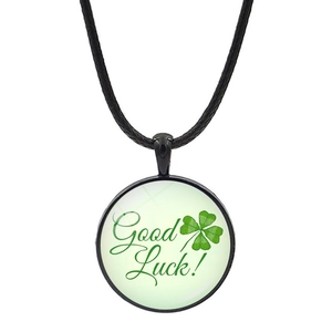 Green four-leaf clover pendant necklace with Good Luck text on a black cord