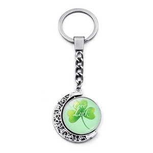Silver lunar keychain featuring a rotating green four-leaf clover and Good Luck text
