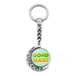 Silver crescent moon keychain with a rotating green Good Luck four-leaf clover pendant