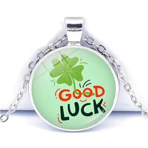 Vue macro du pendentif trèfle à quatre feuilles avec gravure Good Luck et chaîne argentée