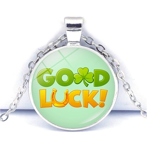 Vue macro du collier trèfle à quatre feuilles argenté avec texte Good Luck et dôme en verre