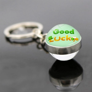 Dettaglio portachiavi a quadrifoglio con sfera di vetro e scritta Good Luck verde