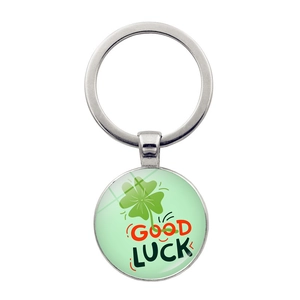 Dettaglio macro del portachiavi a quadrifoglio verde con ciondolo circolare Good Luck