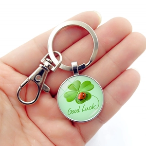 Good Luck keychain with green four-leaf clover and ladybug charm pendant in hand