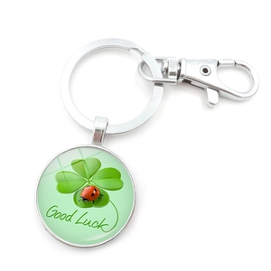 Macro detail of Good Luck glass pendant with green four-leaf clover and ladybug icon