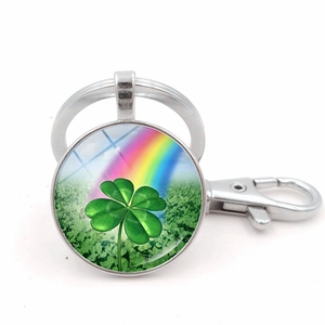 Macro view of polished metal keychain with green four-leaf clover and rainbow pattern
