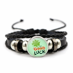 Detail of four-leaf clover glass charm on multi-layer braided leather Good Luck bracelet