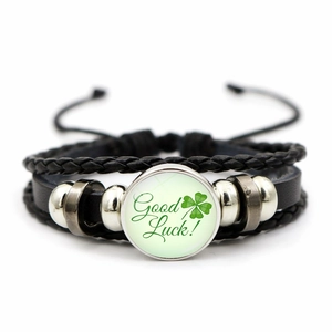 Detailed macro view of woven leather bracelet with Good Luck clover glass charm